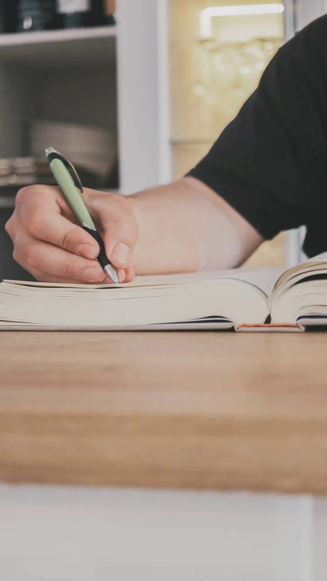 Escribiendo en una libreta sobre la barra de madera