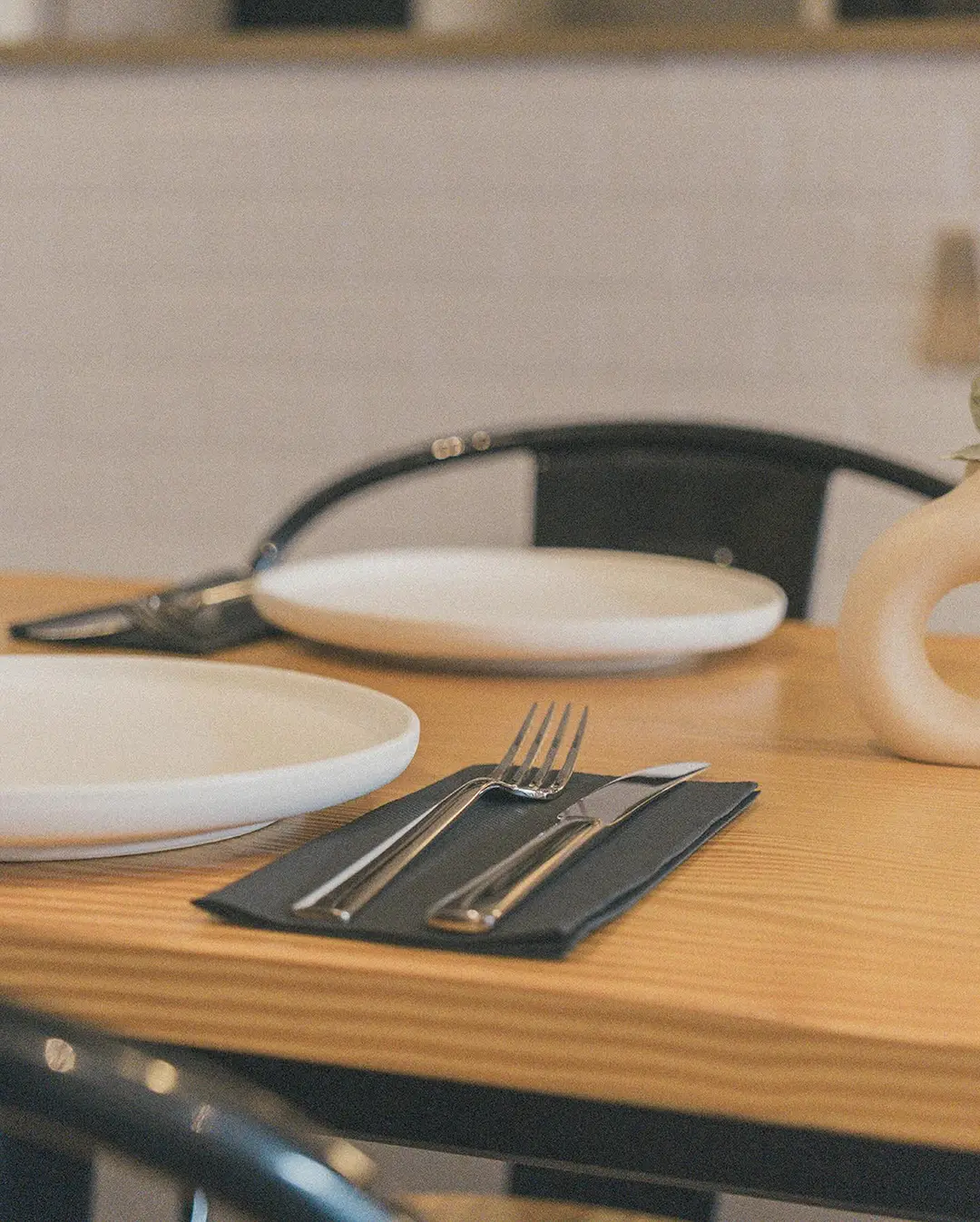 Mesa de pino montada con plato, cubiertos y servilleta
