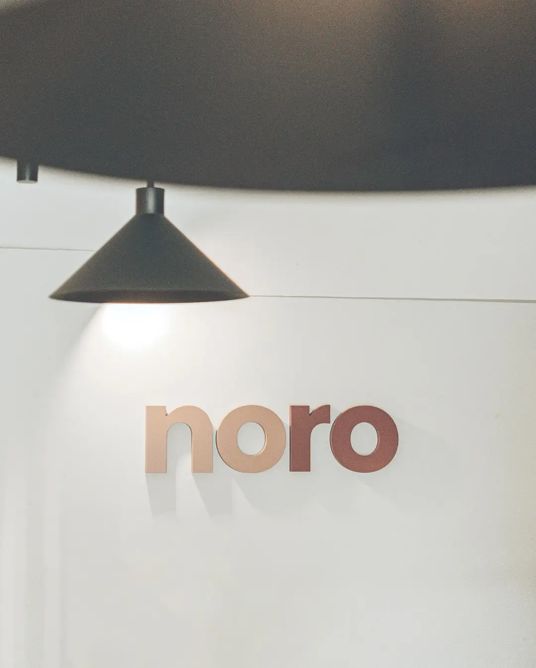 El logotipo de Noro en la pared, bajo la lámpara